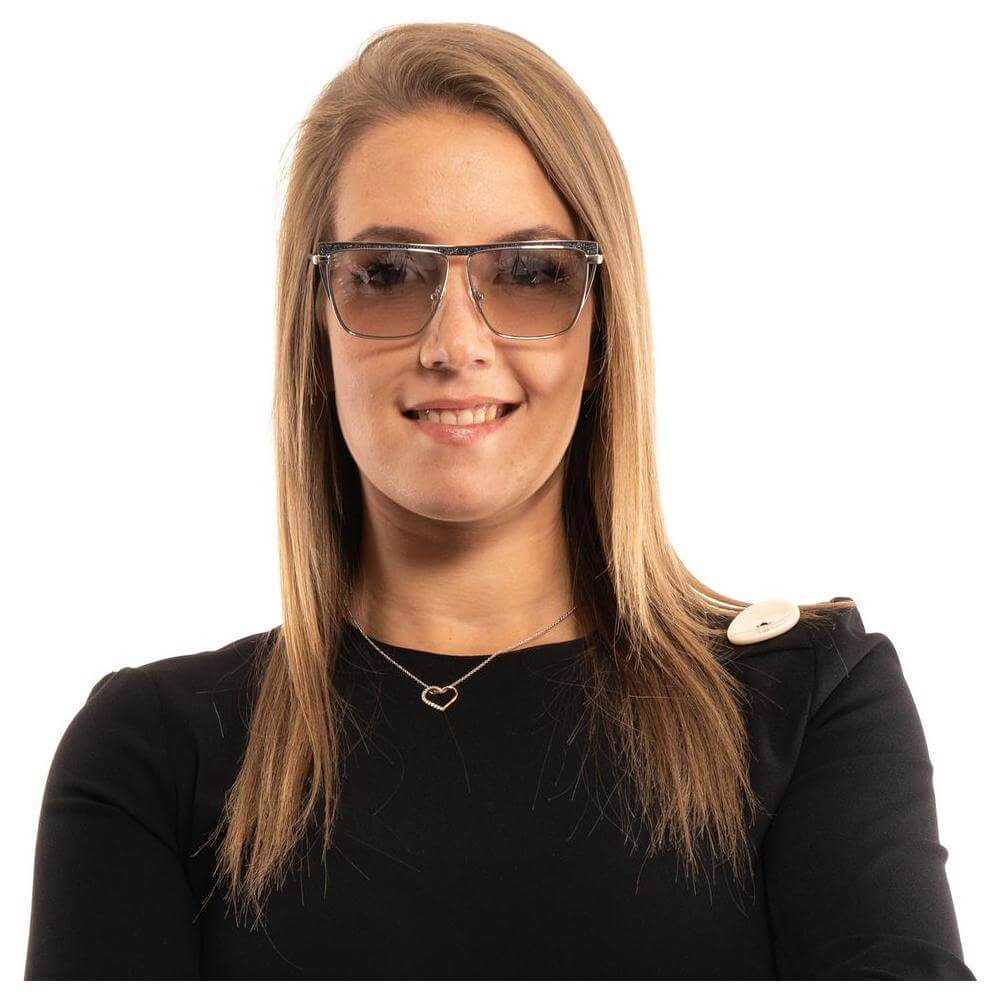 Woman wearing Marciano by Guess silver trapezium sunglasses with yellow mirrored lenses and metal frame, offering 100% UVA & UVB protection.