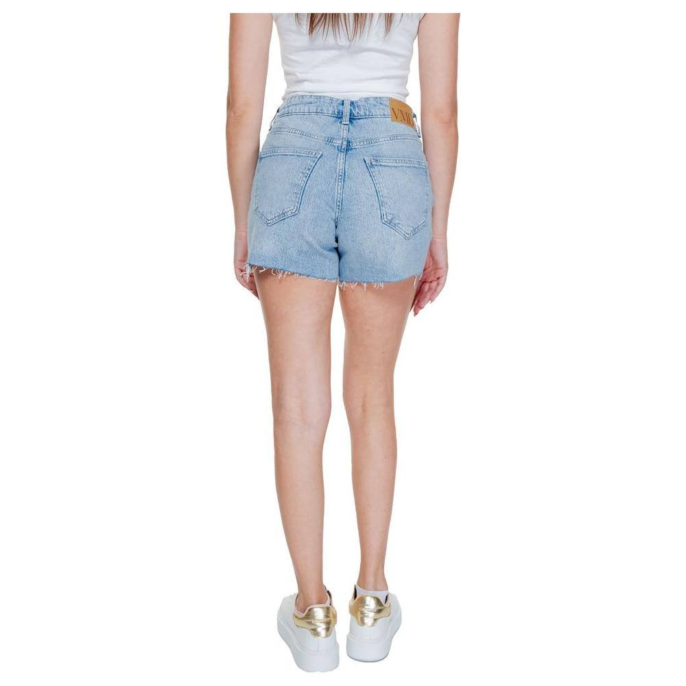 Woman wearing Vero Moda light blue cotton shorts, spring/summer collection, back view, casual style with white sneakers.
