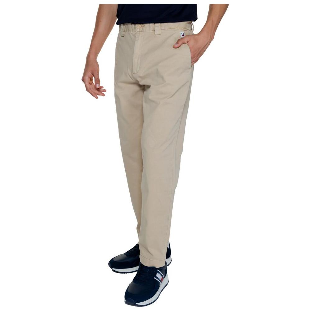Men wearing Tommy Hilfiger gold recycled cotton jeans, fall/winter collection, featuring 96% regenerated cotton and 4% elastane.