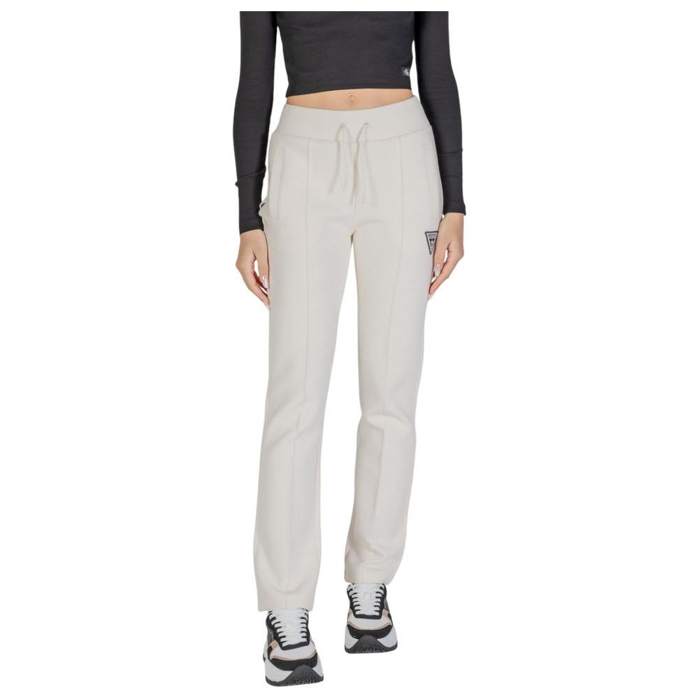 Guess Active cream cotton jeans for women with straight leg design, ideal for casual outings and gym workouts, worn with sneakers.