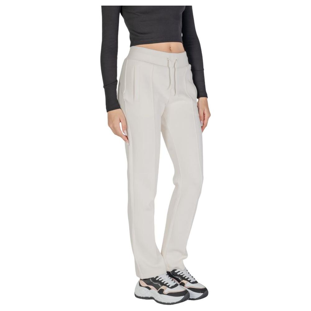 Woman wearing Guess Active cream cotton pants with straight legs, ideal for comfort and style in casual outings.