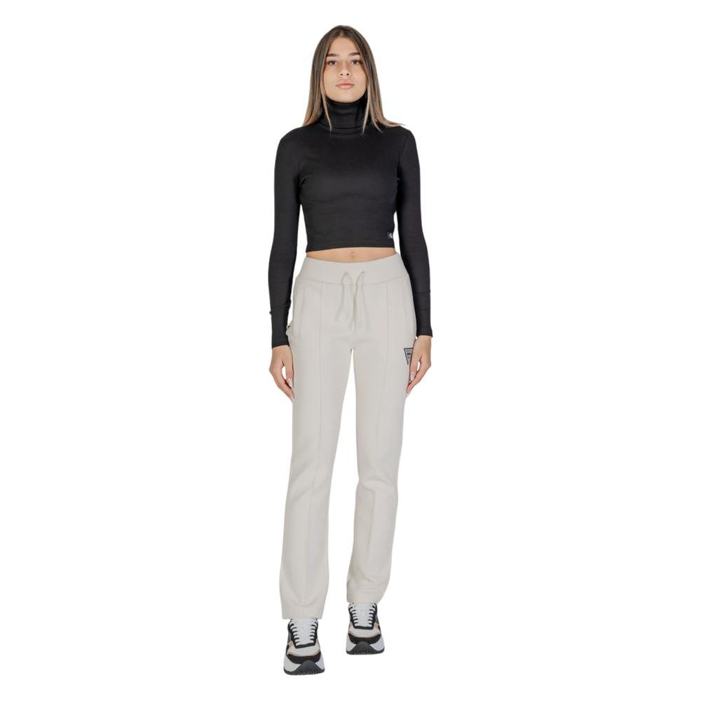Woman in black top wearing Guess Active cream cotton straight leg pants for gym or casual outings.