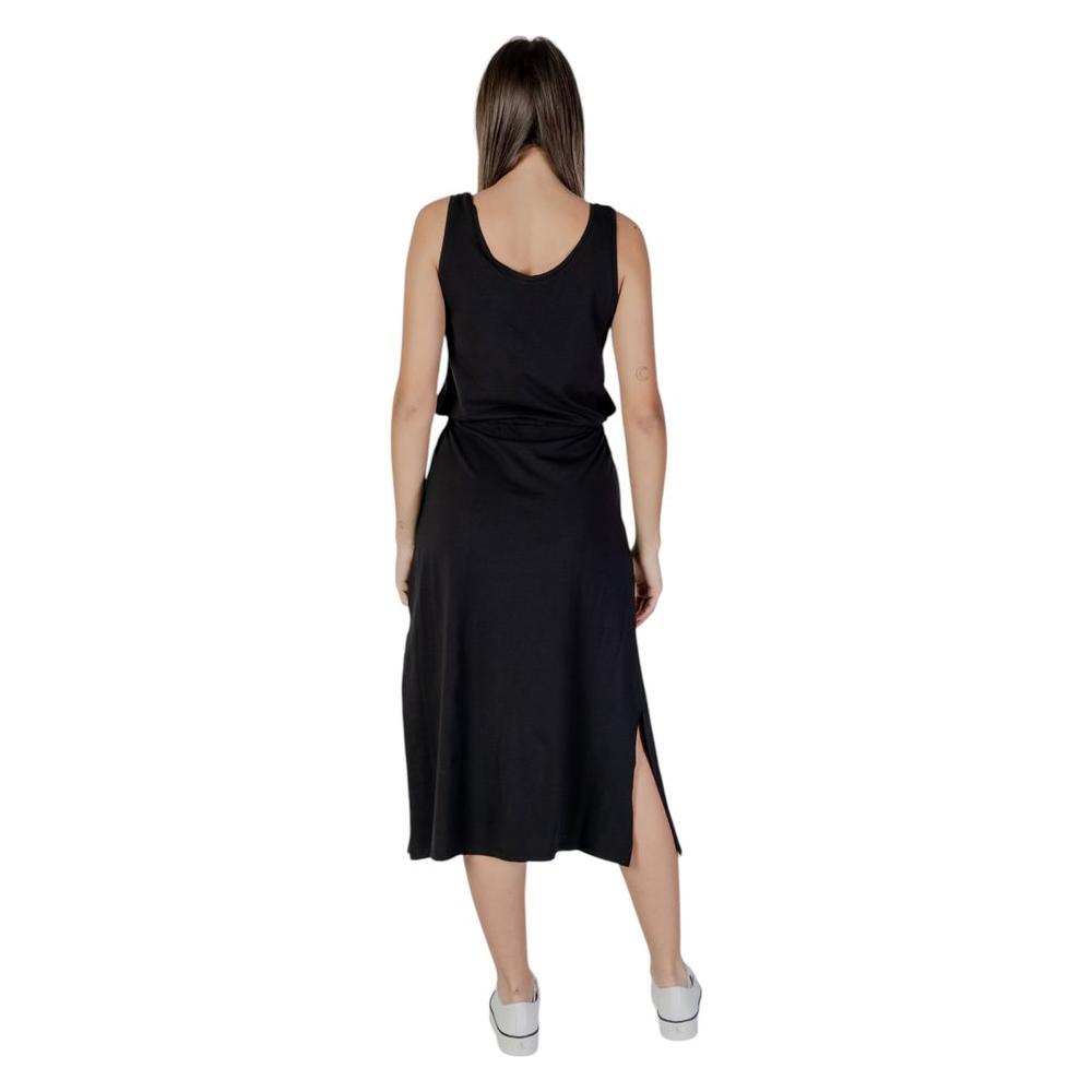 Back view of B.Young black cotton dress for women, spring/summer collection, featuring a sleeveless design and side slit.
