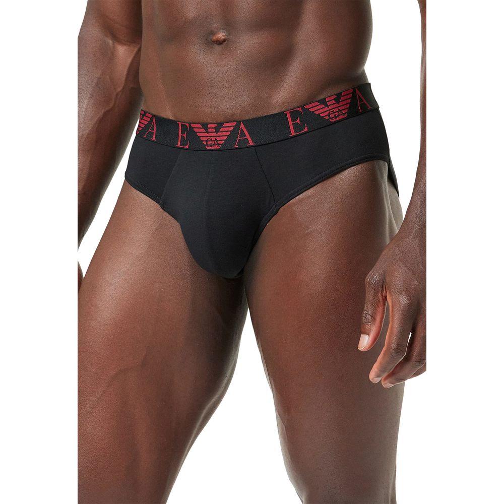 Man wearing Emporio Armani black brief with red logo waistband, showcasing fit and style.