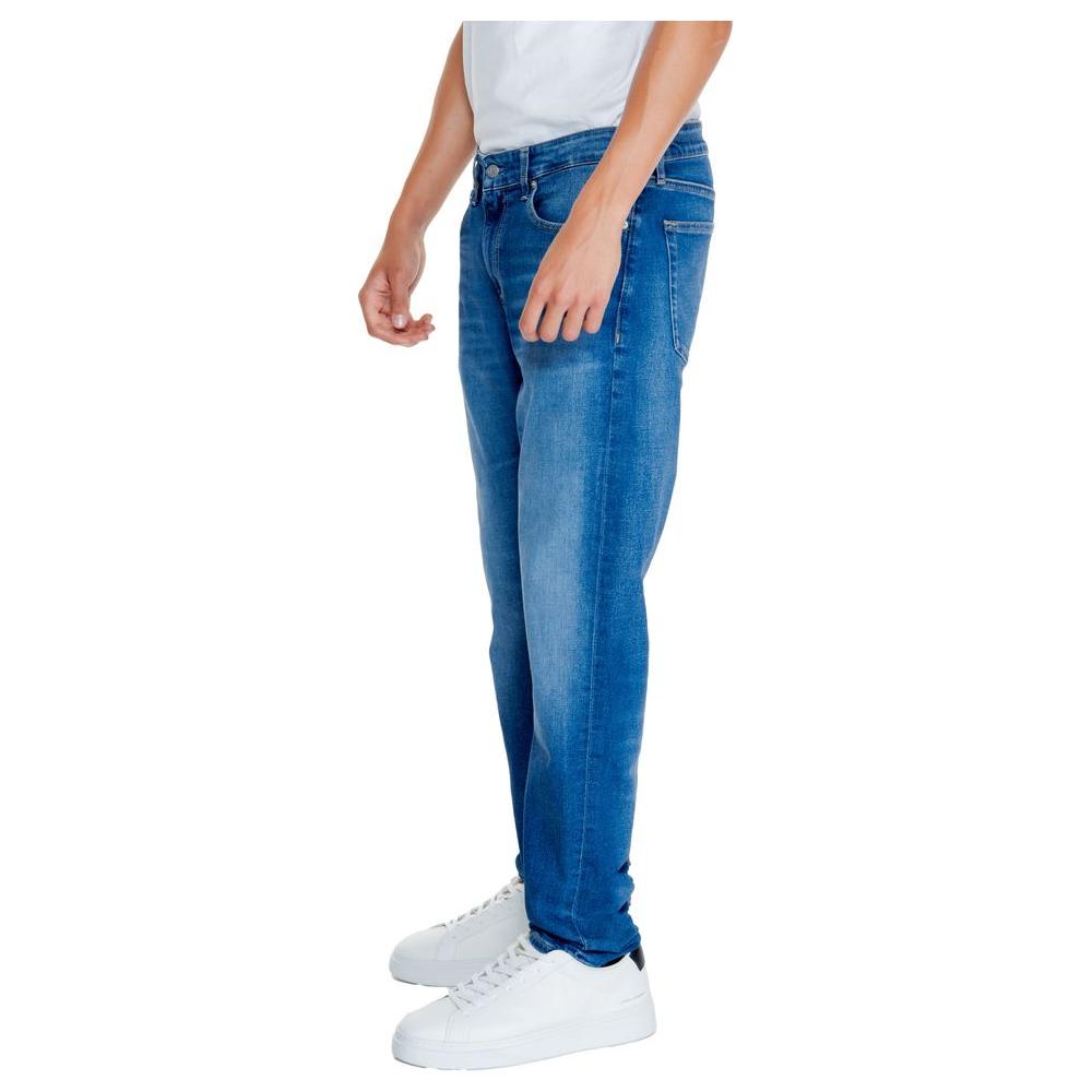 Men's Calvin Klein blue recycled cotton jeans from Fall/Winter collection, side view, with white sneakers.