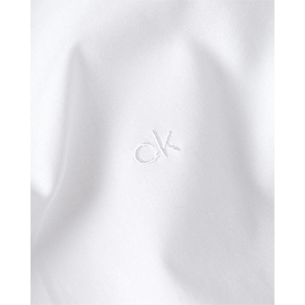 Close-up of Calvin Klein white cotton shirt fabric with CK logo embroidery, showcasing high-quality material and design.