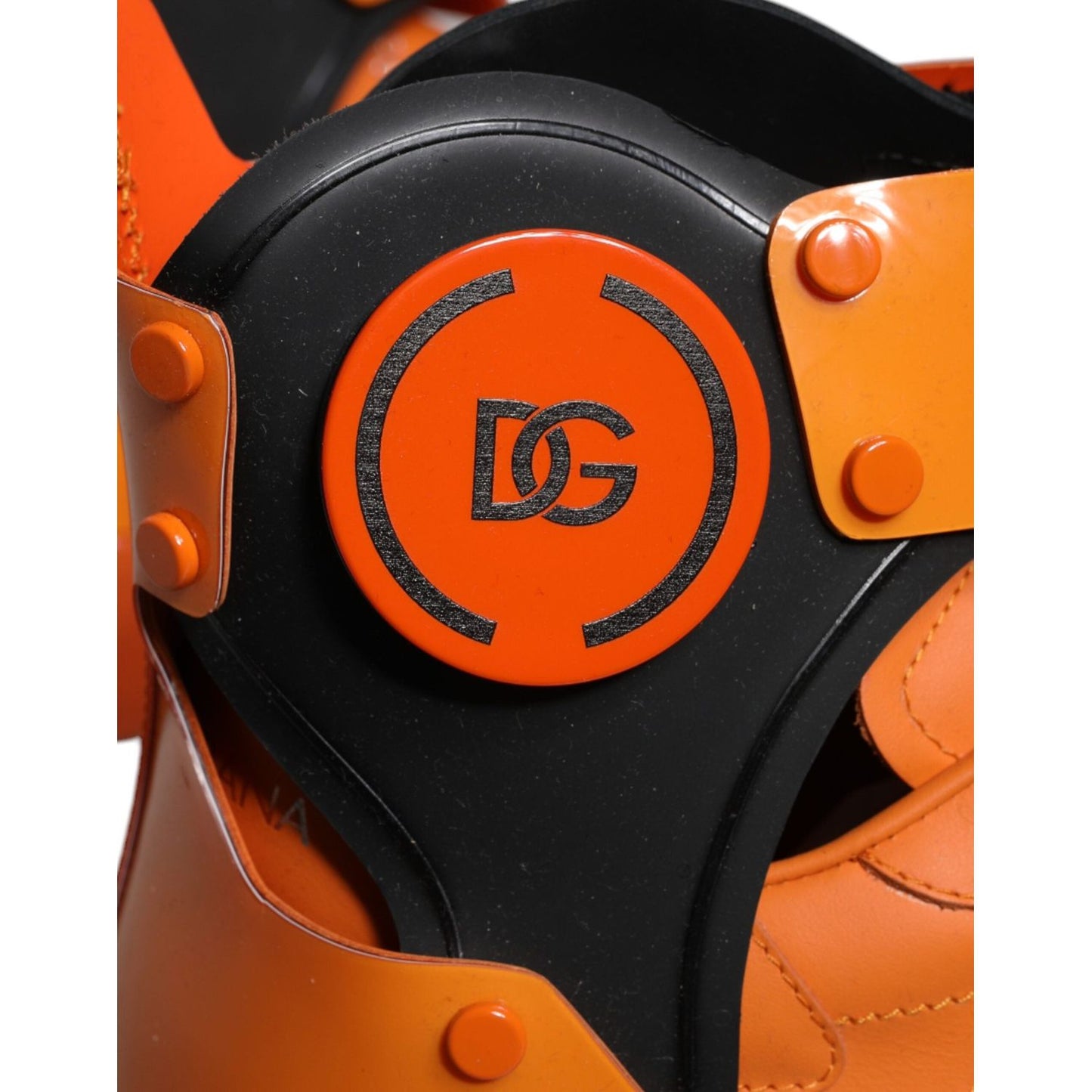 Close-up of Dolce & Gabbana orange multi-panel chunky high top sneakers with logo patch and buckle details.