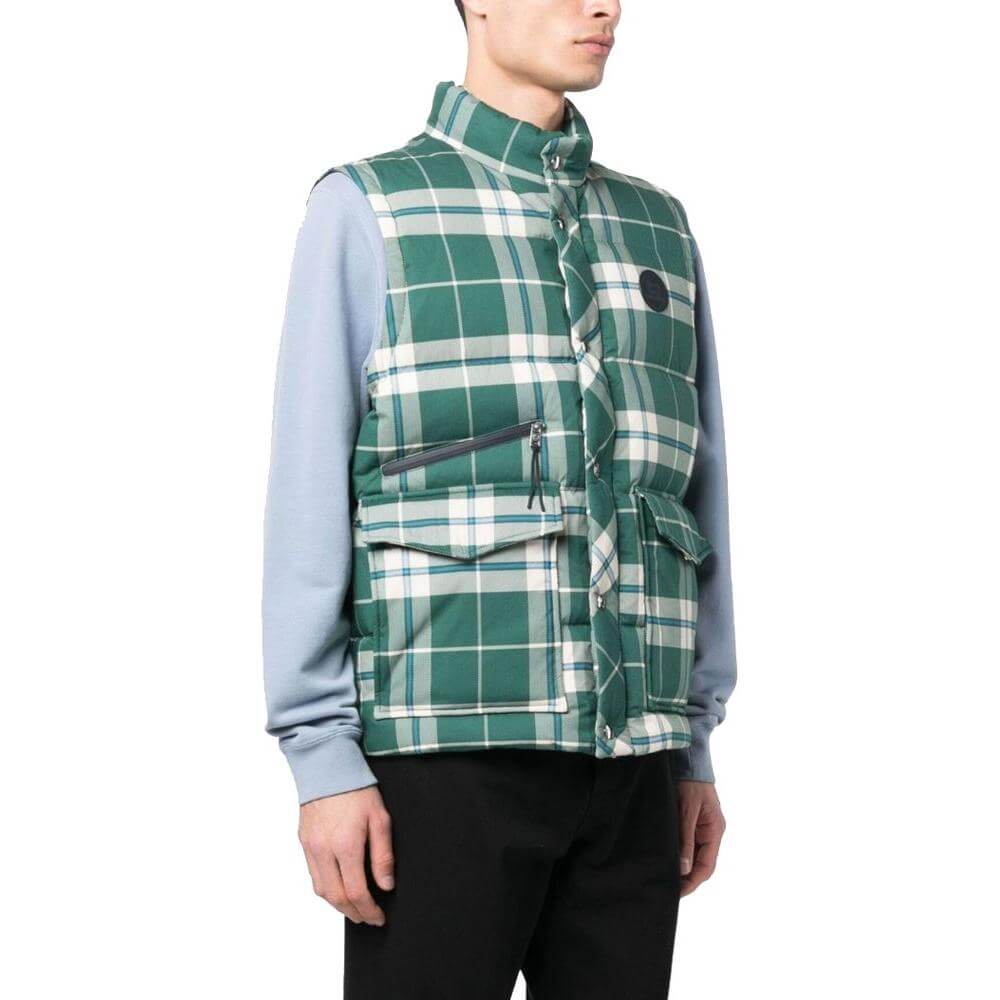 Man wearing Woolrich green polyester vest with checkered pattern, goose down padding, snap buttons, and zip pocket.