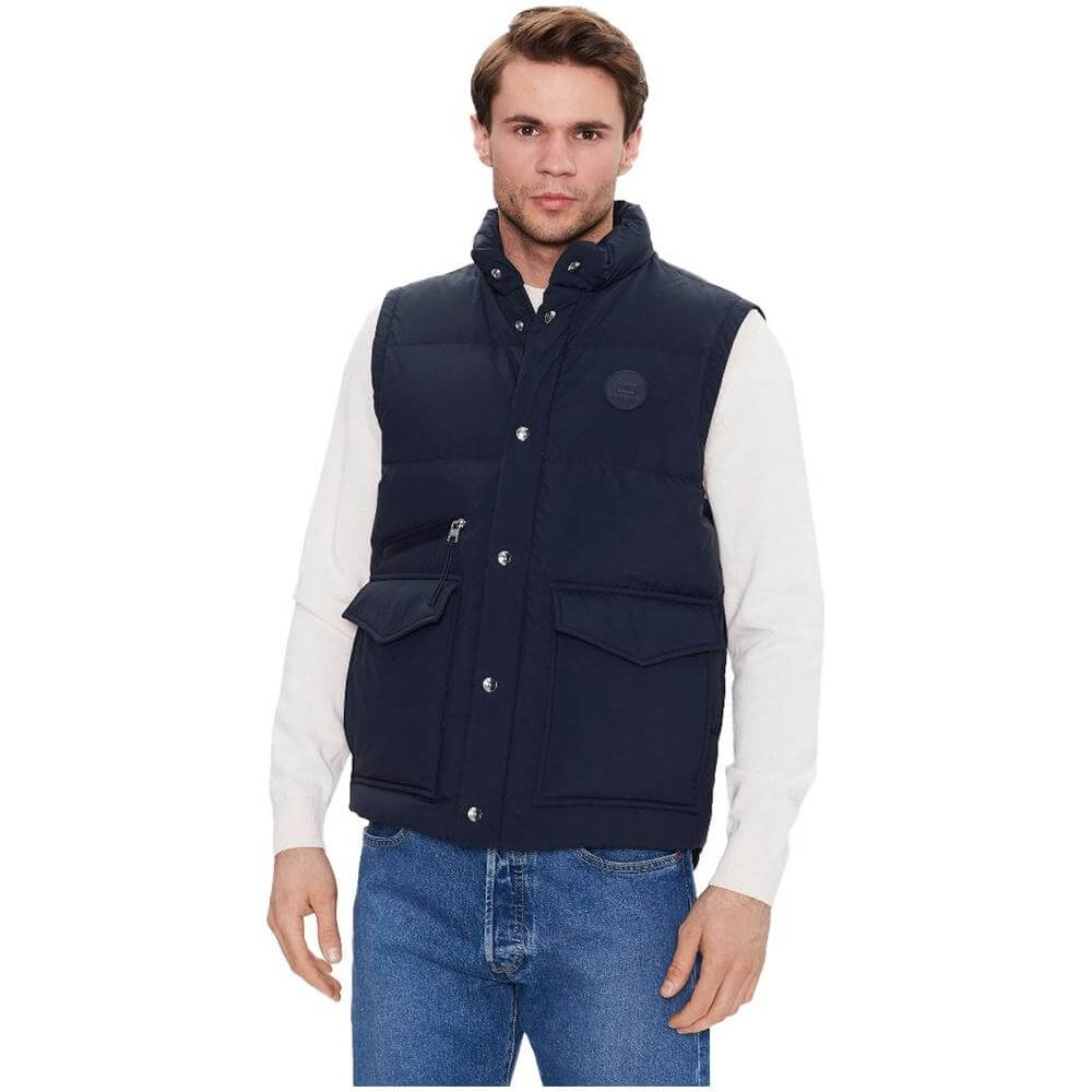 Man wearing Woolrich blue polyester vest with down padding, button and zip fastening, front snap pockets, and zip pocket detailing.