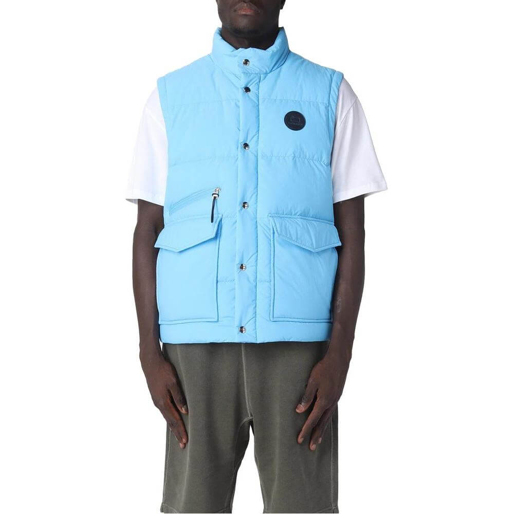 Woolrich light blue polyester vest with goose down padding, button and zip fastening, and front pockets, modeled by a person.