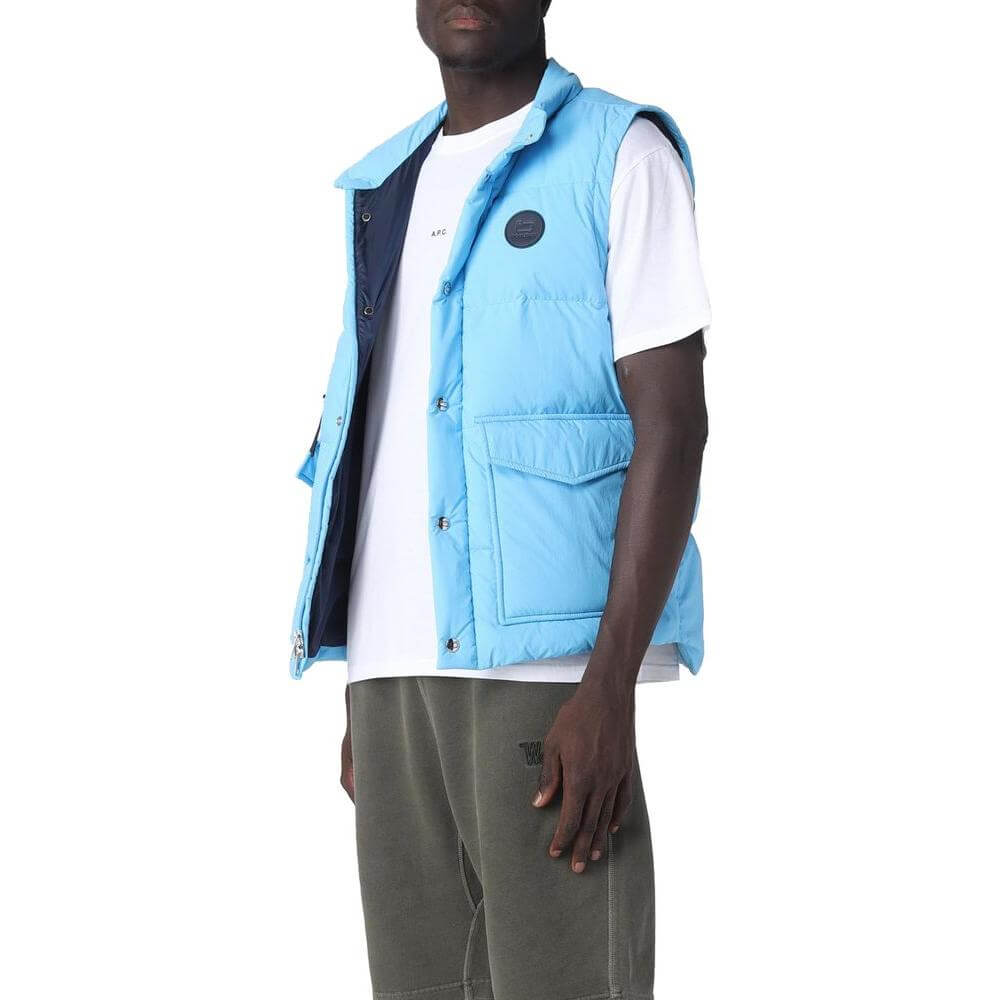 Woolrich light blue polyester vest with goose down padding, button and zip fastening, and front pockets on a person wearing casual attire.