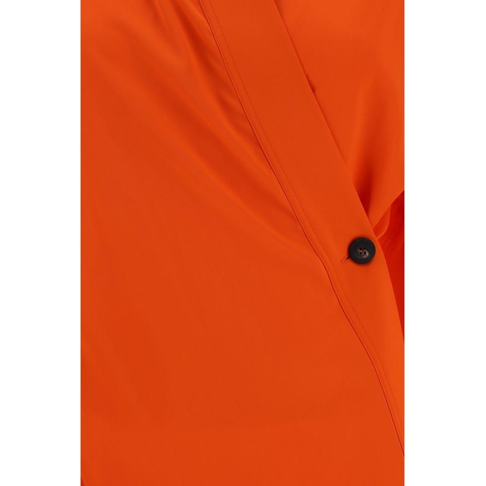 Close-up of orange Ferragamo shirt featuring a kimono closure with a single side button and monochrome design.
