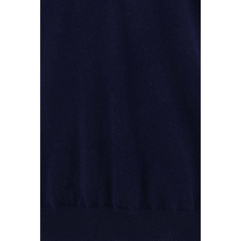 Close-up of Brunello Cucinelli navy cashmere turtleneck sweater with ribbed hem and monochrome pattern.