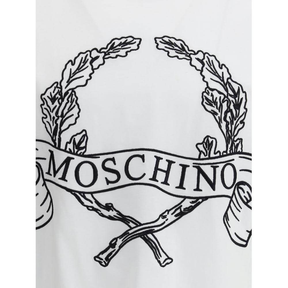 Close-up of Moschino Logoed T-Shirt featuring embroidered monogram, ribbed crew neck, and luxurious design details on cotton fabric.