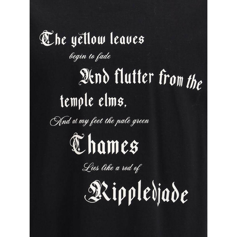 Close-up of black T-shirt with white gothic text reading poetic verses, showcasing bold and artistic typography.