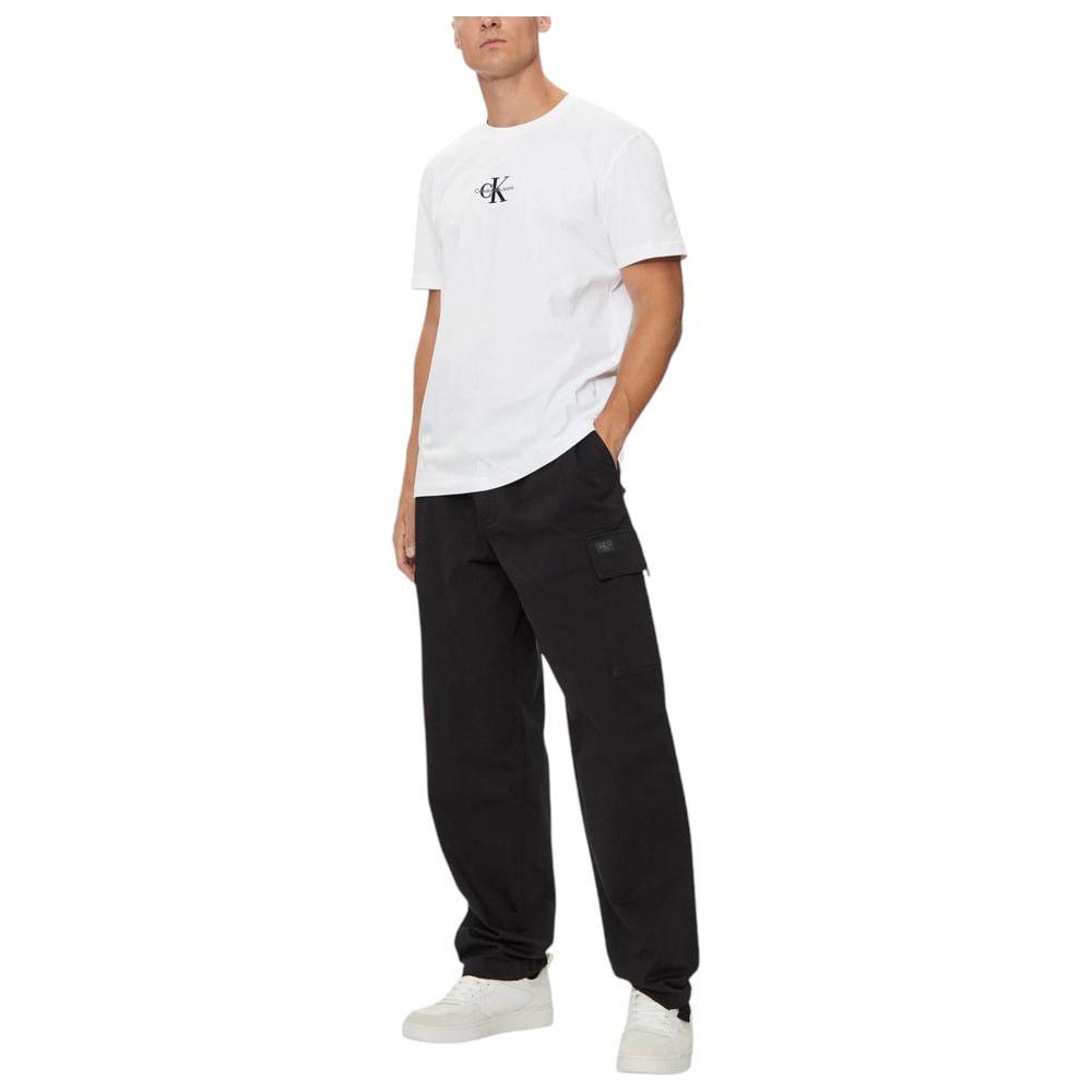 Calvin Klein Jeans white recycled cotton t-shirt with logo, modeled with black pants and white shoes, showcasing minimalist design.