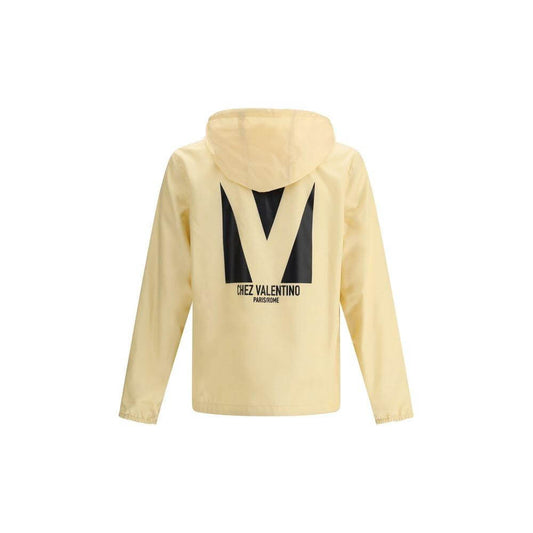 Valentino waterproof jacket in beige with hood, black monogram and logo on back, perfect for stylish rain protection.
